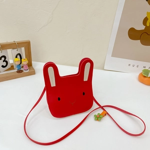 Detailed close-up of a red rabbit-shaped toddler crossbody bag on a white table