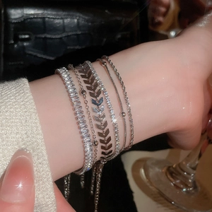 Detail of silver layered bracelet set with sparkling zircon on a wrist with luxury vibes