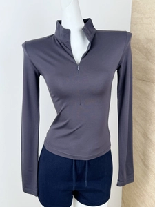 Detail of slim fit dark grey long sleeve sports top with quarter-zip standing collar