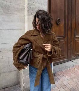 Close-up of brown faux suede jacket featuring a notched lapel and a matching waist belt