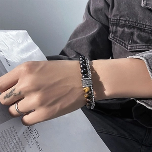 Detail view of matte black beads and tiger eye stones combined with a silver metal chain