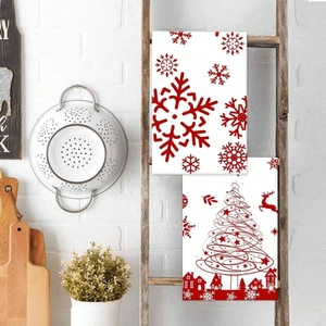 Detail of Christmas microfiber kitchen towels featuring red snowflake and reindeer patterns