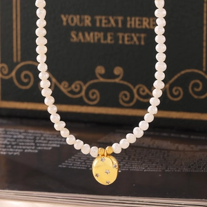 Pendentif ovale en or avec zircons en étoile et perles d'eau douce sur un collier chic