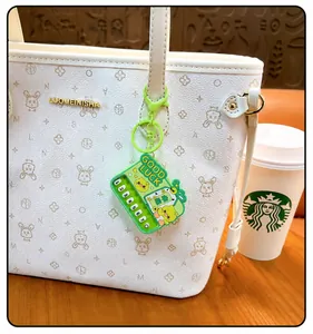 Detailansicht eines grünen Mini-Klavier-Schlüsselanhängers mit Good Luck Text an einer Tasche