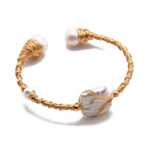 Handcrafted gold wire-wrapped bangle featuring baroque and round natural pearls