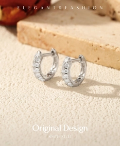 Detail of silver S925 huggie earrings with pave cubic zirconia on a stone base