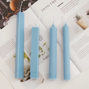 Blue rectangular and ribbed pillar candles arranged on a magazine for DIY decor