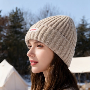 Berretto in maglia spessa beige con etichetta rossa per il calore invernale