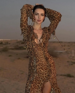 Detail view of leopard print chiffon dress with deep V-neck and ruffle trim accents