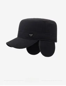 Detailed macro view of the black winter flat top hat with foldable earflaps and metal logo