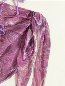 Detail of purple marble print bikini fabric with slim drawstring straps and mesh texture