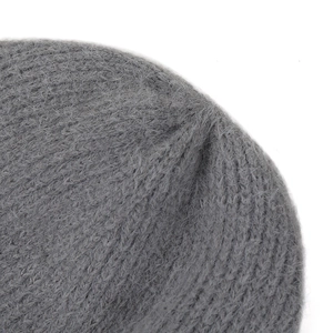 Gros plan sur le bonnet gris montrant la texture moelleuse en mohair et la maille chaude