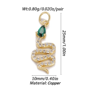 Detailed view of a golden snake pendant with clear zircons and a green gemstone