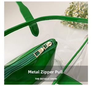 Detail view of the golden metal zipper puller on the green transparent jelly tote bag