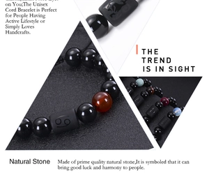 Macro shot of 10mm black obsidian and tiger eye beads with engraved zodiac sign detail