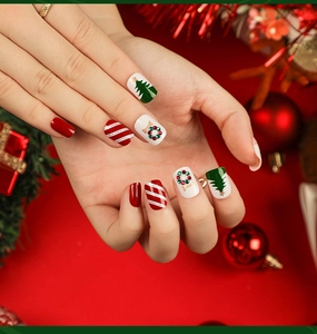 Close-up of Christmas press-on nails with festive candy cane and holiday tree designs