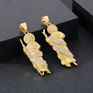 Gros plan détaillé de pendentifs Saint Jude dorés avec strass brillants sur fond noir