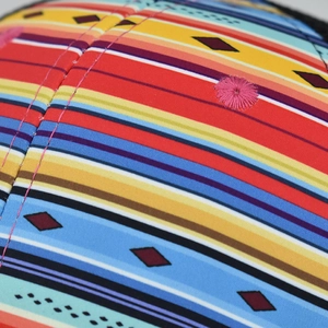 Macro detail of multi-color striped fabric with cross diamond pattern and embroidery