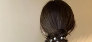 Detailed view of pearl hair scrunchie with elastic black rope worn on hair