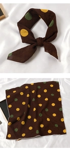 Détail d'un foulard en coton-lin marron à pois jaunes et verts avec des coutures blanches