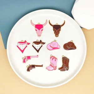 Detail of pink and brown enamel cowboy charms including boots and hats in a white tray