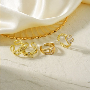 Set of four gold-tone adjustable rings with butterfly and zircon stones on silk background
