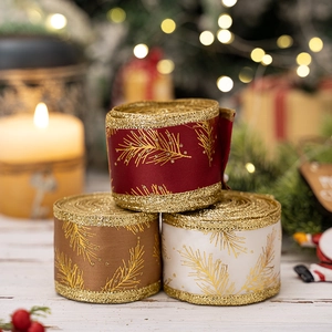 Christmas glitter ribbons in burgundy, gold, and cream on a white wooden background