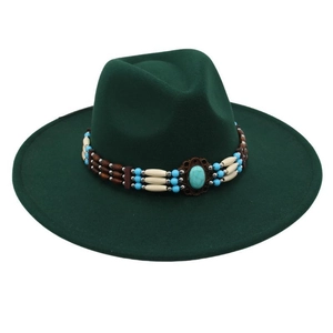 Close-up of ethnic style turquoise beads and oval stone on dark green wool felt fedora hat