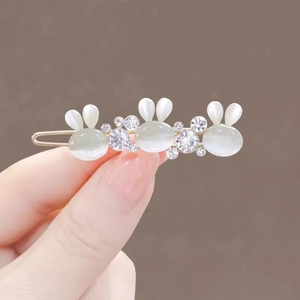Elegant gold hair clip featuring three opal-style rabbits with sparkling rhinestones