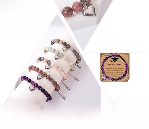 Gros plan sur les perles d'agate naturelle et le pendentif cœur poli du bracelet tissé
