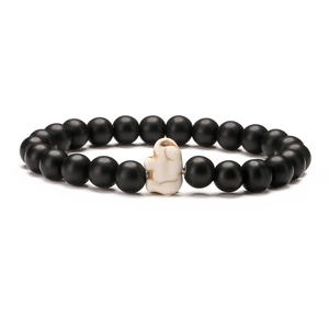 Detail of matte black beads and white marble elephant charm on elastic bracelet