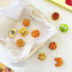 Detail of assorted resin mini food brooches including burgers and croissants set on a tray