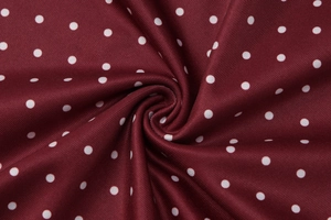 Macro di tessuto a costine bordeaux a pois bianchi con texture morbida e plissettata