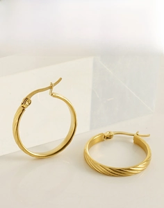 Detail of 18K gold-plated stainless steel hoop earrings with spiral twisted texture