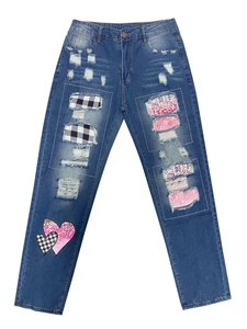 Detail der blauen Jeans mit rosa Pailletten-Patches und schwarz-weißem Karomuster-Besatz