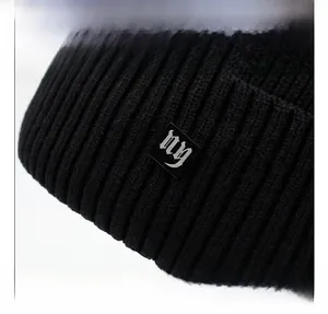 Gros plan sur le bonnet en tricot côtelé noir montrant la texture et l'écusson logo gothique