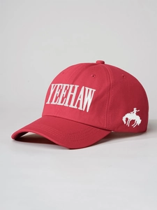 Detail of red cotton baseball cap with white Yeehaw embroidery and cowboy silhouette logo