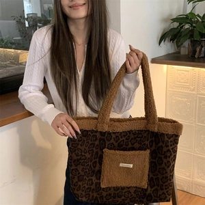 Detailed shot of leopard print tote bag with brown plush trim and front utility pocket
