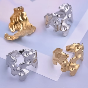Macro detail of irregular 18K gold plated molten lava rings in silver and gold finish