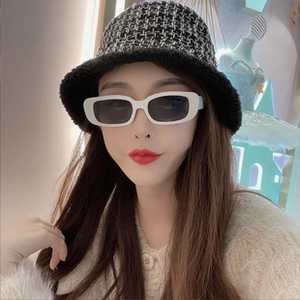 Detail of a chic black and white checkered winter bucket hat with a plush fur brim