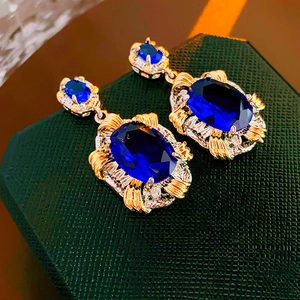 Detailed view of vintage oval blue zircon earrings with a dual-tone gold and silver finish