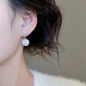 Elegant silver needle earrings featuring a sparkling zircon and a round white pearl drop