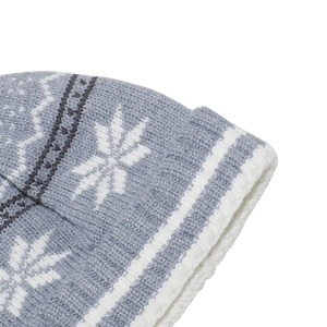 Close-up of winter knit beanie showing detailed grey snowflake patterns and warm stitching