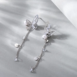Elegant silver butterfly tassel earrings with pearls and crystals on light grey background