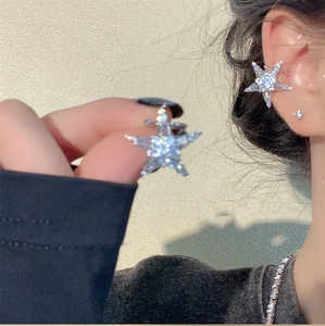 Detailed view of silver starfish stud earrings with sparkling cubic zirconia on a model