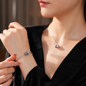 Detail of silver chain necklace and bracelet featuring blue and clear zircon beads