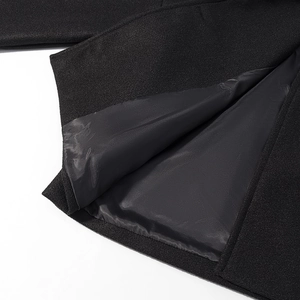 Detailed macro view of black wool jacket hem with smooth inner lining and neat stitching