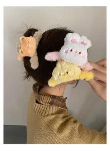 Detail of plush animal hair claw clips with bear, rabbit and chick designs worn by model