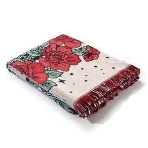 Detailed close-up of rose floral jacquard weave blanket with red fringed edges