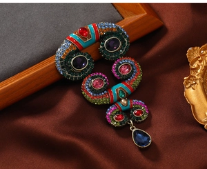 Detailed view of vintage crystal brooch with colorful rhinestones and teardrop pendant